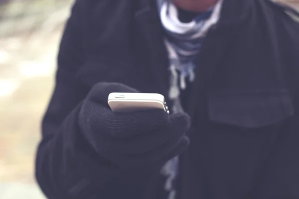 Glowes, soğuk hava ile elinde cep telefonu — Stok fotoğraf