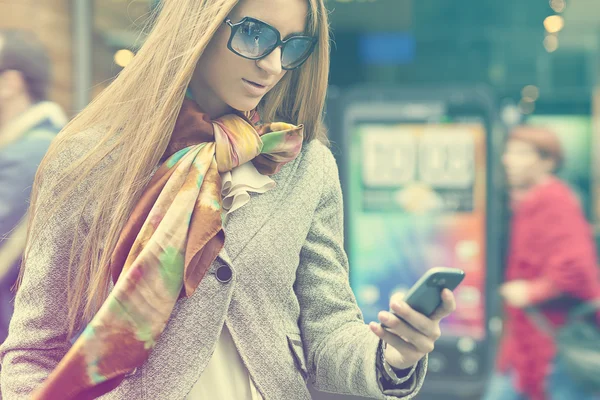 Vrouw met smartphone lopen op straat — Stockfoto