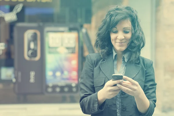 Jonge vrouw met mobiele telefoon wandelen — Stockfoto