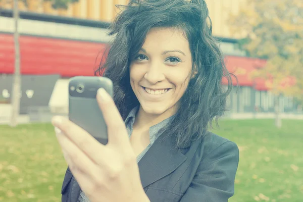 Mulher jovem com telefone celular andando — Fotografia de Stock