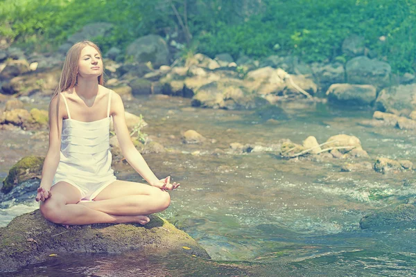 Bella donna Yoga pratico sul fiume in natura Fotografia Stock