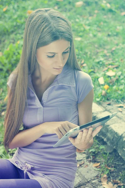 Belle femme avec ordinateur tablette dans le parc — Photo