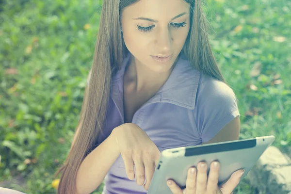 Mulher bonita com computador tablet no parque — Fotografia de Stock