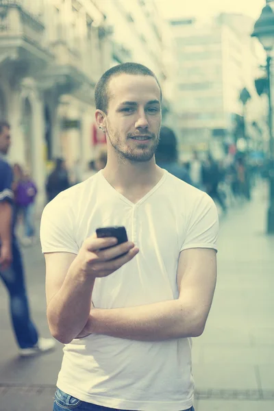 Jonge man met mobiele telefoon wandelen — Stockfoto