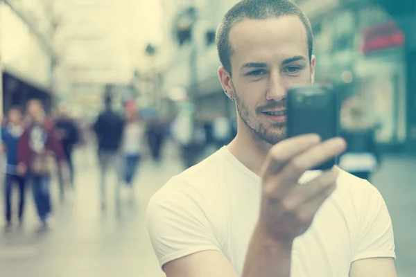 携帯電話の歩行と若い男 — ストック写真