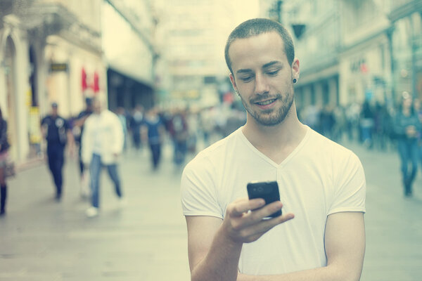 Young Man with cell phone walking
