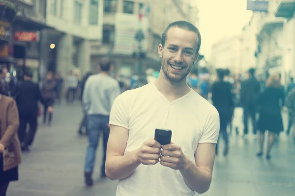 Adam cep telefonu yürüme ile gülümseyen — Stok fotoğraf