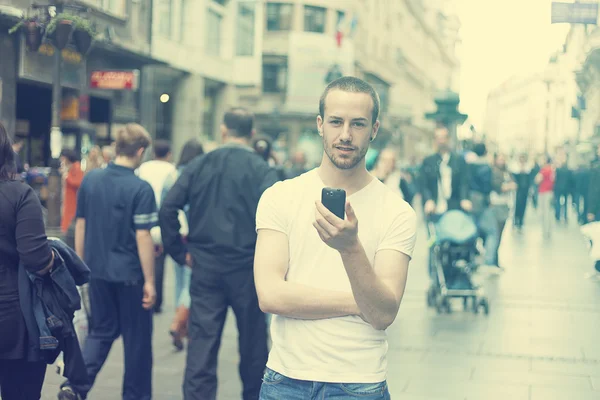 Homem jovem na cidade com telefone celular — Fotografia de Stock