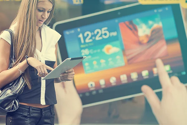 Young Woman with tablet computer walking on street — Stock Photo, Image