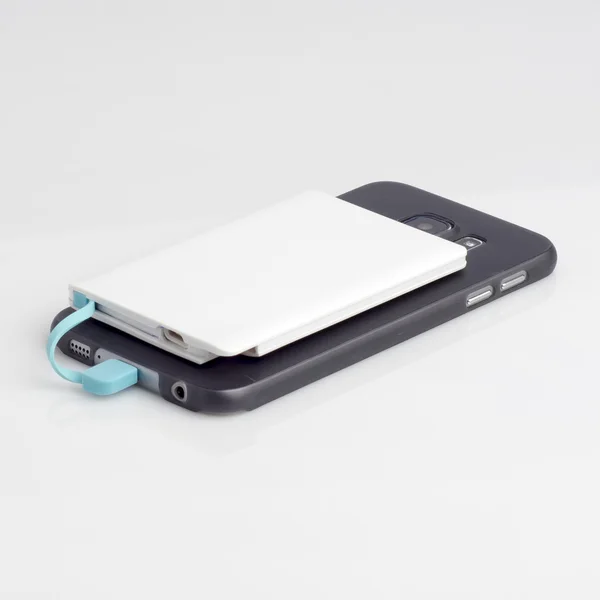 Carga de un teléfono inteligente con powerbank en blanco — Foto de Stock