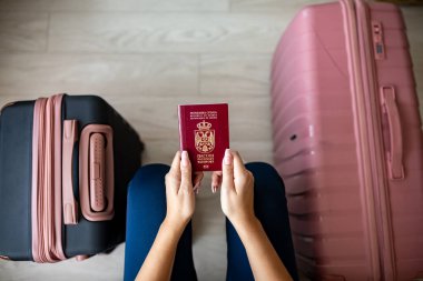 Sırp pasaportu kadınların elinde ve bavullar seyahat için hazır