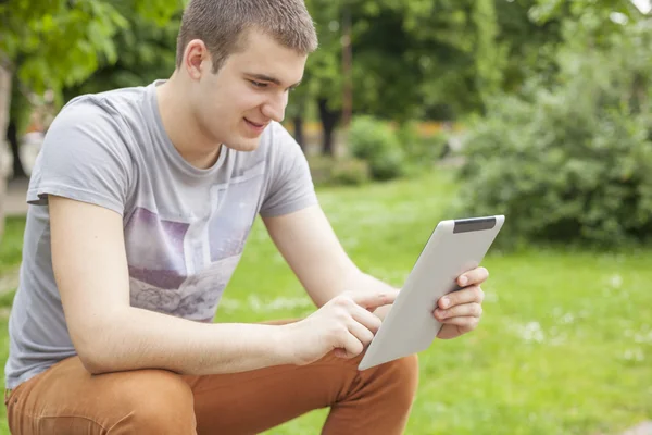 Człowiek z komputera typu tablet w parku — Zdjęcie stockowe