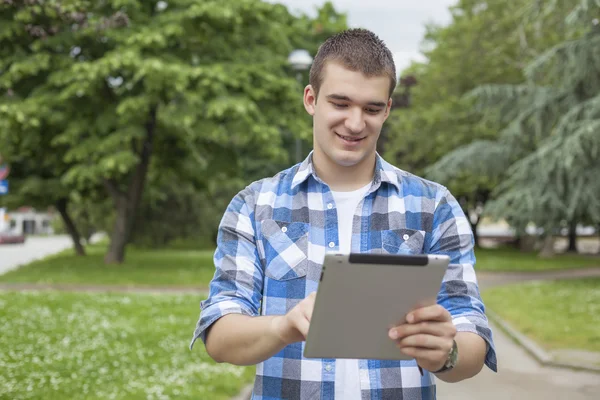 Tablet bilgisayar adamla Park'ta rahatlayın — Stok fotoğraf