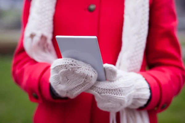 Kvinna i ull handskar håller smart-telefon — Stockfoto