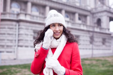 Kırmızı ceket ve yün şapka ve eldiven smartph ile güzel kadın