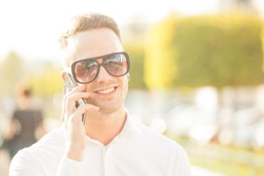 Elinde cep telefonu olan bir adam.