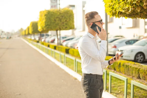 Homme d'affaires avec téléphone portable et tablette dans les mains — Photo