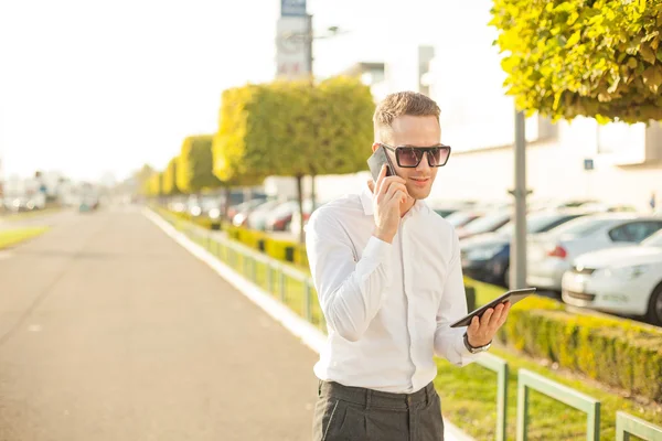Affärsman med mobiltelefon tablett i händer — Stockfoto