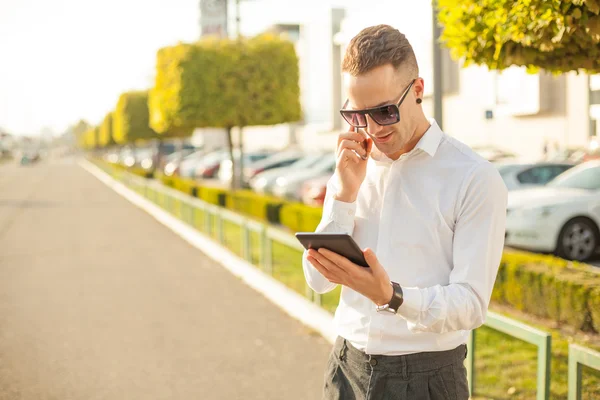 Podnikatel s mobilní telefon a tablet v rukou — Stock fotografie