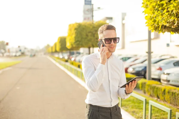 Affärsman med mobiltelefon och tablet i händer — Stockfoto