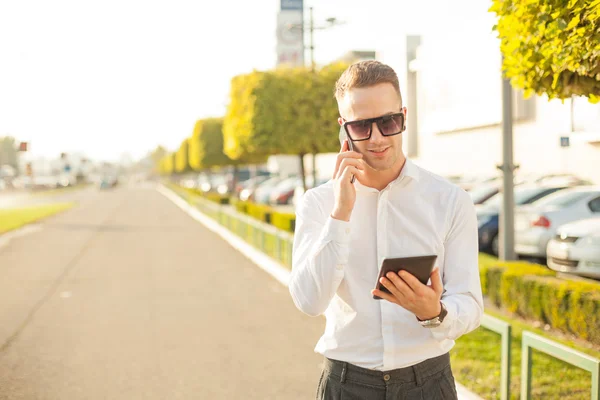 Podnikatel s mobilní telefon a tablet v rukou — Stock fotografie