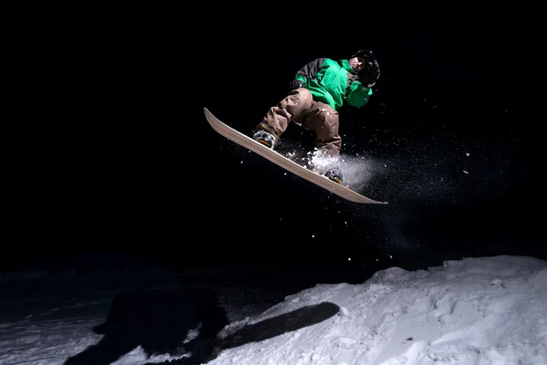 Snowboarder pulando à noite — Fotografia de Stock