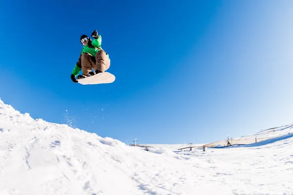 Snowboarder saltando contro il cielo blu — Foto Stock