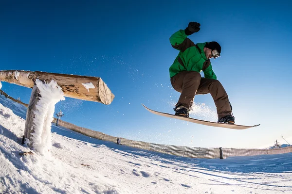 Snowboarder springt gegen blauen Himmel — Stockfoto