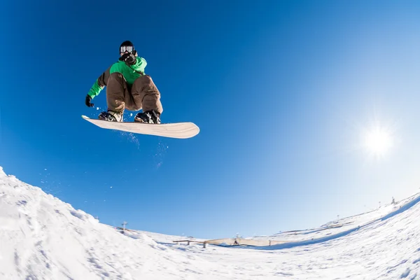 Snowboarder saltando contro il cielo blu — Foto Stock