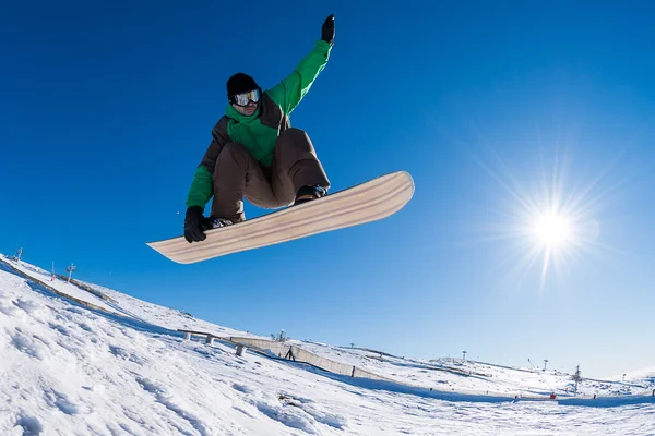 Snowboardista skákání proti modré obloze — Stock fotografie