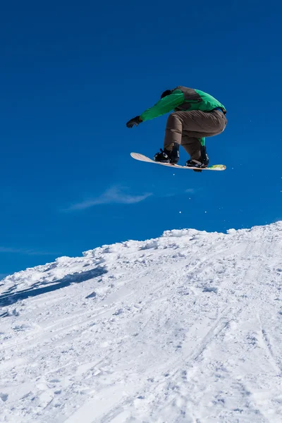 Snowboardåkare hoppar mot blå himmel — Stockfoto