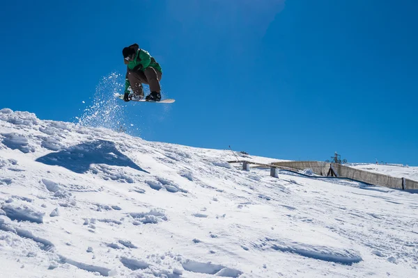 Snowboarder saltando contro il cielo blu — Foto Stock