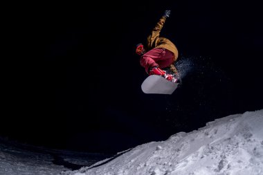 Karanlık gece gökyüzünde atlama snowboarder