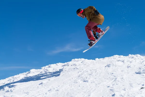 Snowboarder skacze na błękitne niebo — Zdjęcie stockowe