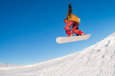 Mavi gökyüzüne atlayan snowboardcu
