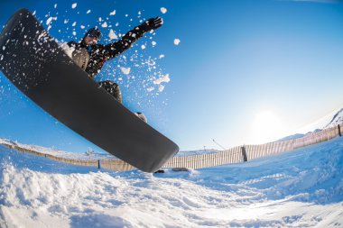 Mavi gökyüzüne atlayan snowboardcu