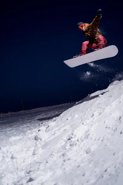 Snowboardista skákat v noci — Stock fotografie