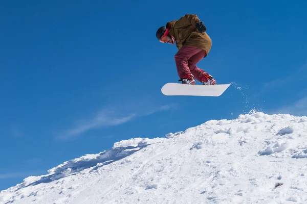 Snowboarder saltando contro il cielo blu — Foto Stock