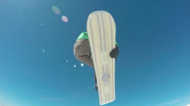 Mavi gökyüzüne atlayan snowboardcu