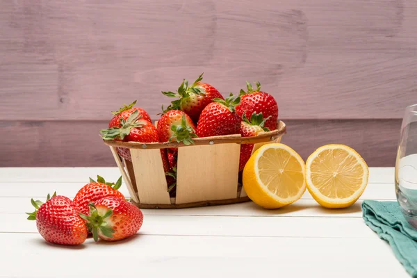 Strawberries in a small basket and lemon — Stock Photo, Image