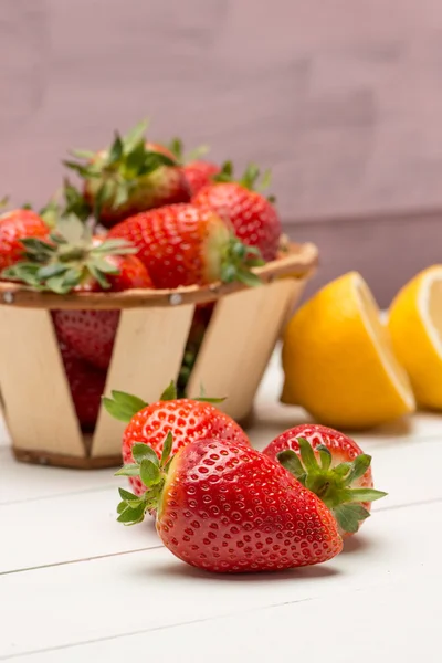 Strawberries in a small basket and lemon — Stock Photo, Image