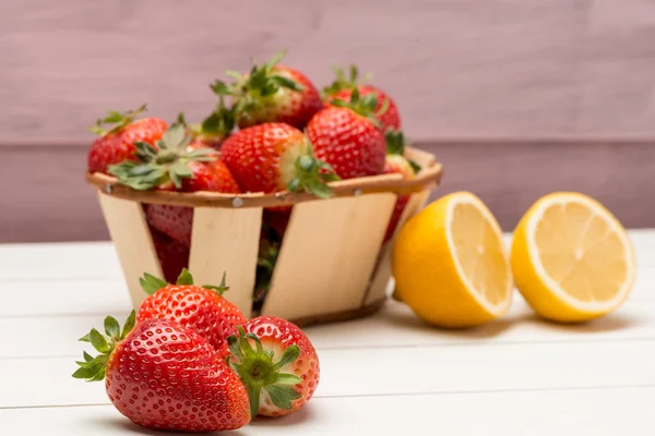 Strawberries in a small basket and lemon — Stock Photo, Image