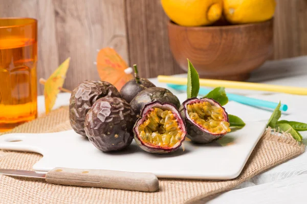 Frutas de la pasión en bandeja de cerámica blanca sobre fondo de mesa de madera . —  Fotos de Stock