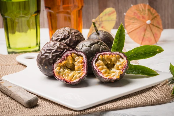 Frutas de la pasión en bandeja de cerámica blanca sobre fondo de mesa de madera . — Foto de Stock