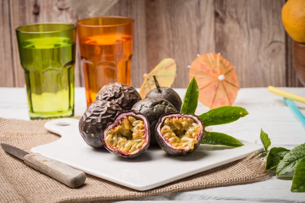 Frutas de la pasión en bandeja de cerámica blanca sobre fondo de mesa de madera . —  Fotos de Stock