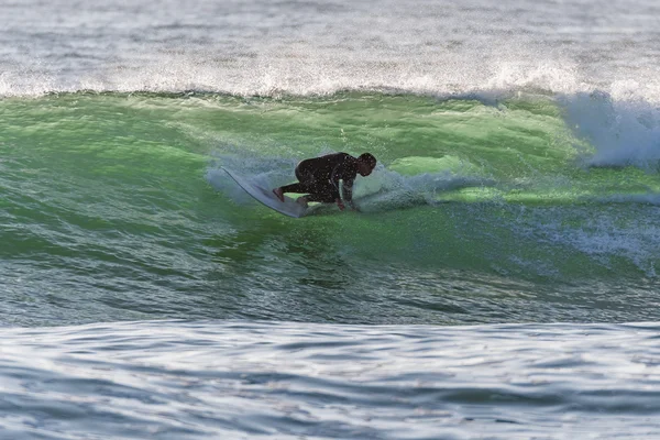 Larga tabla surfeando las olas al atardecer — Foto de Stock