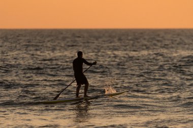 Adam paddleboarding siluet