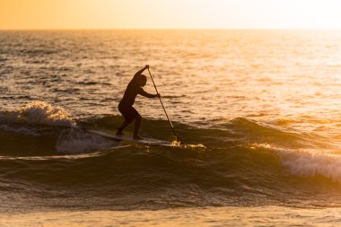 Gün batımında paddler siluet kadar stand