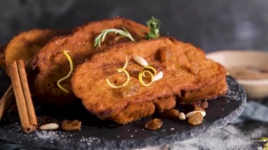 Traditional Christmas Rabanadas with lemon zest, raisins, pine nuts and cinnamon. Spanish Torrijas or french toasts close up on the countertop