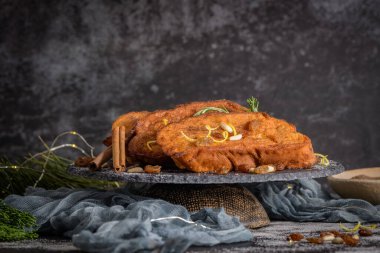 Traditional Christmas Rabanadas with lemon zest, raisins, pine nuts and cinnamon. Spanish Torrijas or french toasts close up on the countertop